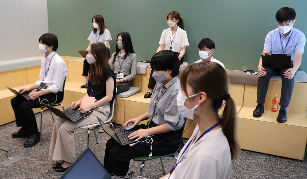 Scene from Tokyo H/Q meeting room, connected online with each hub in a hybrid format.